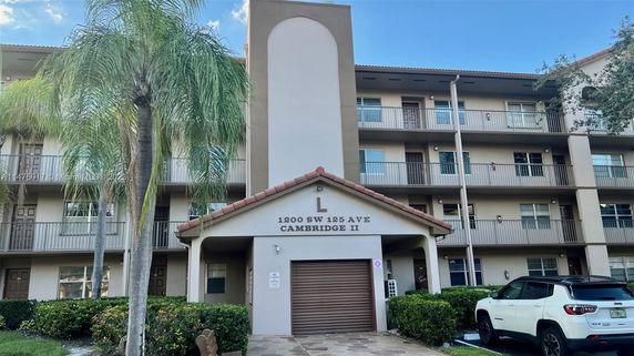 Front view of a multi-story residential building with a central entrance and balconies.
