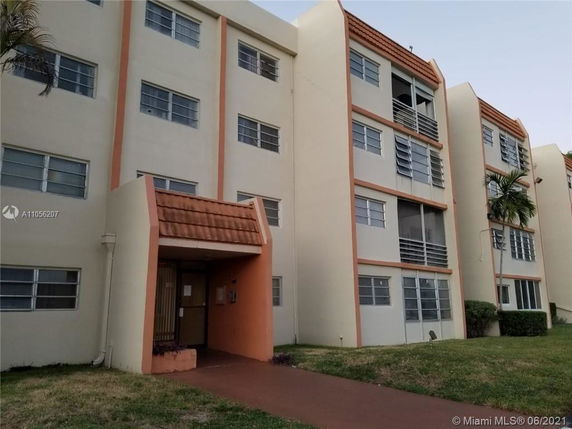 Front view of a multi-story apartment building with balconies.