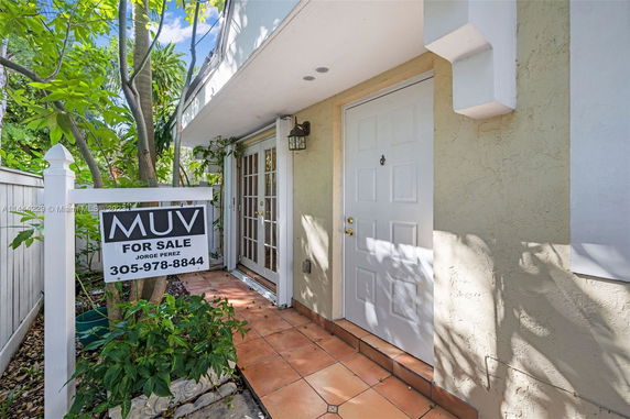 Front entrance of a house with a for sale sign.