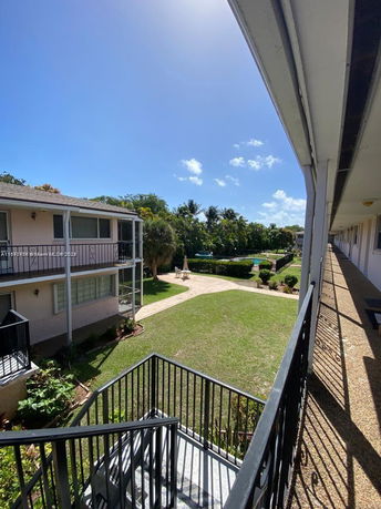 View of courtyard area between buildings with visible stairway and lawn.