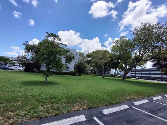 View of a building with a grass lawn and trees.