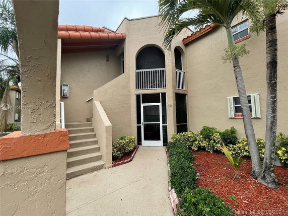 Front view of a multi-story building with stairway and balcony.