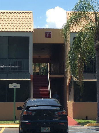 Front view of a multi-level building with a tiled roof and stairs leading up to a corridor.
