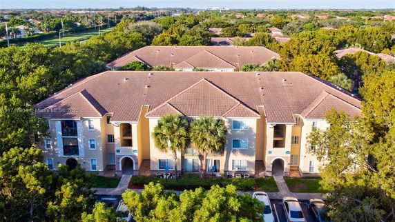 Front view of a multi-story residential building with tiled roofs and balconies.