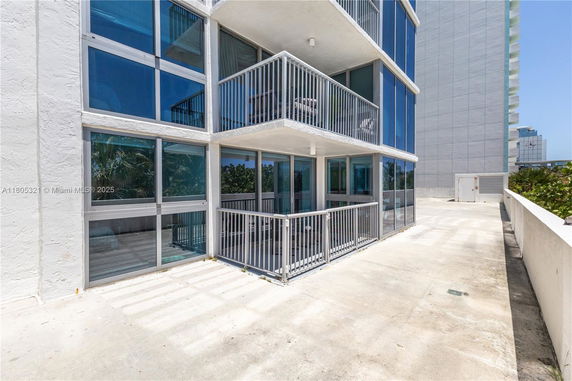 Front view of a multi-story building with large windows and balconies.