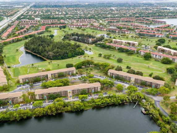 Panoramic view of residential complexes surrounded by greenery and water bodies.