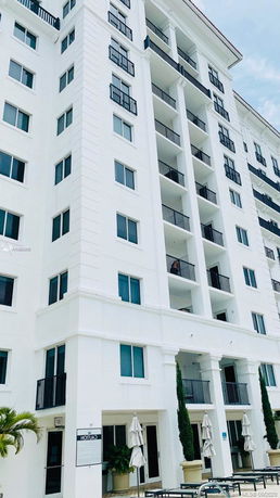 Front view of a multi-story residential building with balconies.