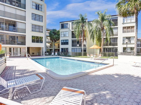 Outdoor swimming pool area with surrounding residential buildings.