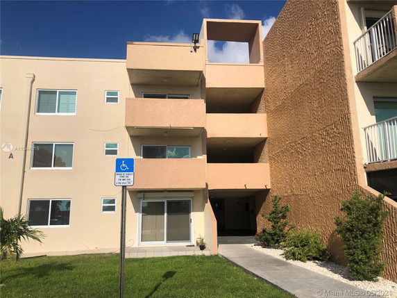 Front view of a multi-story apartment building with balconies.