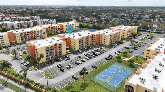 Aerial view of a residential complex with multiple multi-story buildings and parking areas.