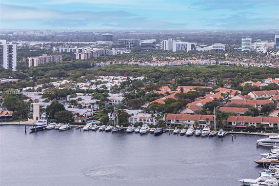 Wide angle view of residential area with buildings and a marina with boats.