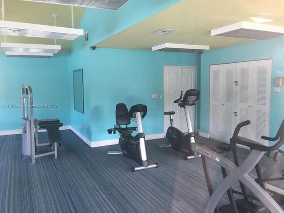 Indoor gym area with exercise equipment including elliptical machines and stationary bikes.