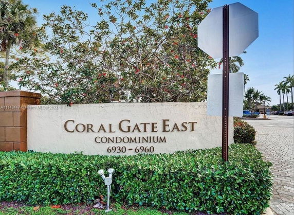 Entrance sign for Coral Gate East Condominium with surrounding greenery.