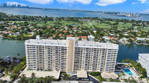 Aerial view of a large, multi-story residential building overlooking water and surrounding areas.