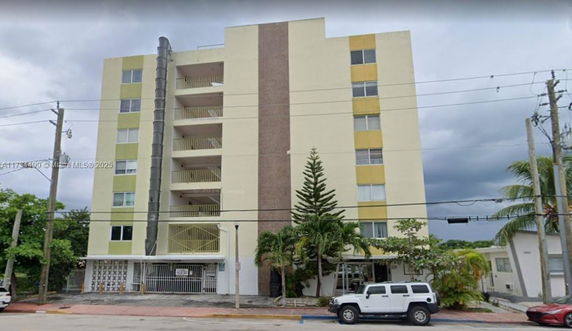 Front view of a multi-story apartment building with balconies.