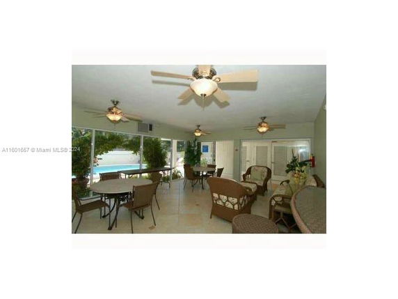 Indoor seating area with tables, chairs, and ceiling fans.