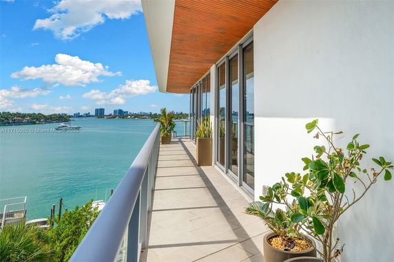 Balcony view overlooking a body of water with buildings in the distance.
