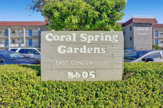 Front view of a residential condominium building with parking area.