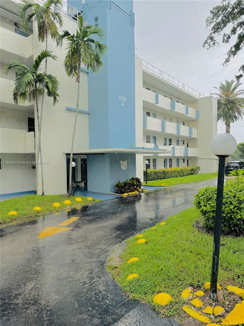 Front view of a multi-story residential building with blue and white exterior.