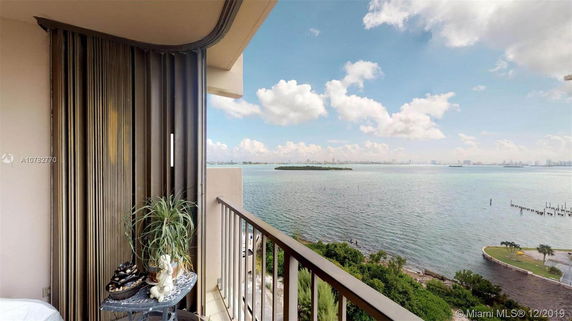 Panoramic view from a balcony overlooking a body of water and distant skyline.