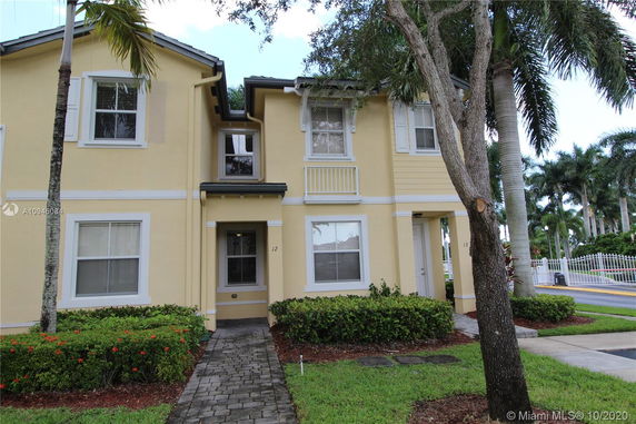 Front view of a two-story townhouse with yellow exterior and white trim.