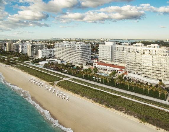 Panoramic view of beachfront buildings alongside a sandy beach.