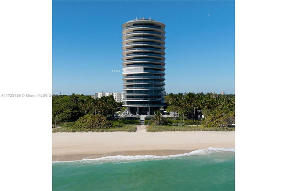 Front view of a high-rise beachfront building with circular balconies.