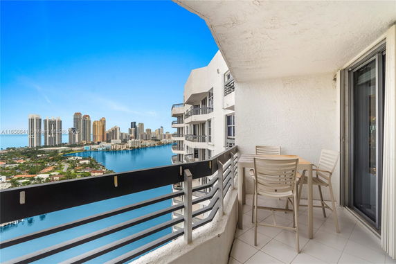 Balcony view of city skyline across calm water.