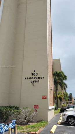 Front view of a multi-story building with signage reading 'Meadowbrook Towers'.