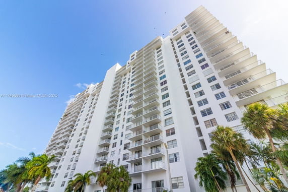 Upward view of a tall residential building with multiple balconies.