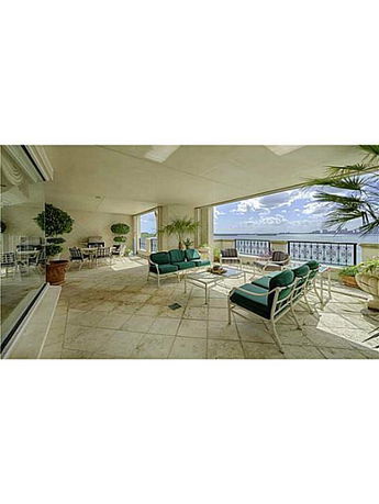 A spacious balcony with seating areas overlooking a scenic view.