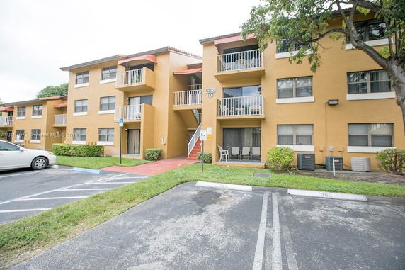 Front view of a three-story apartment building with balconies.