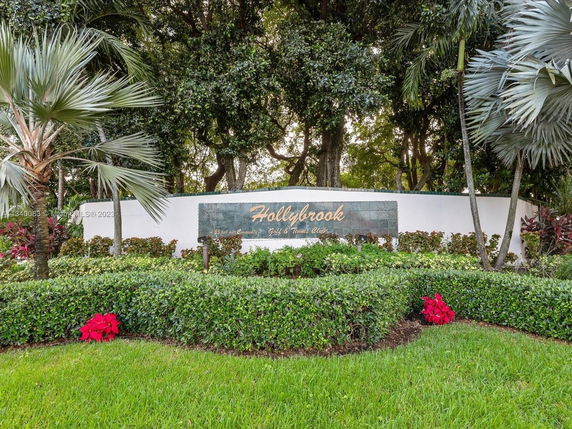 Signage for Hollybrook amidst landscaped greenery and trees.