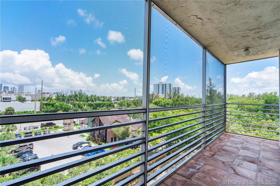 View from a balcony showing surrounding areas and distant buildings.