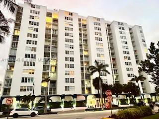 Front view of a multi-story apartment building with balconies.