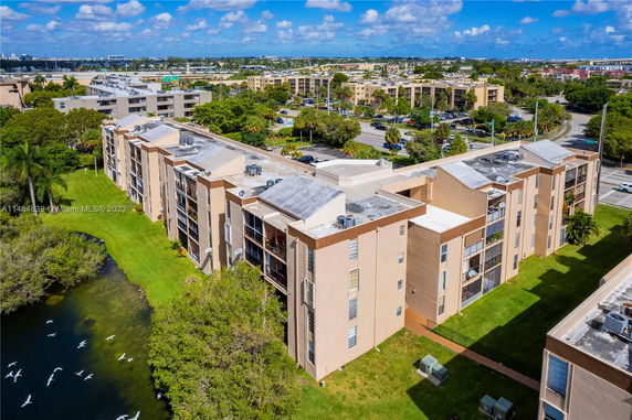 Aerial view of apartment buildings with flat roofs and surrounding landscape.