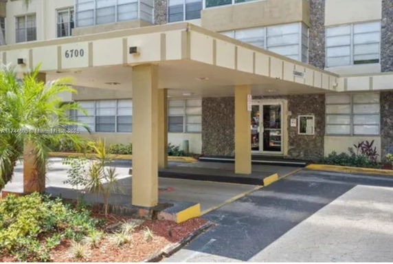Entrance area of a building with covered parking and driveway.