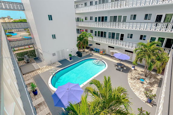 Outdoor area with a swimming pool surrounded by a multi-story building.