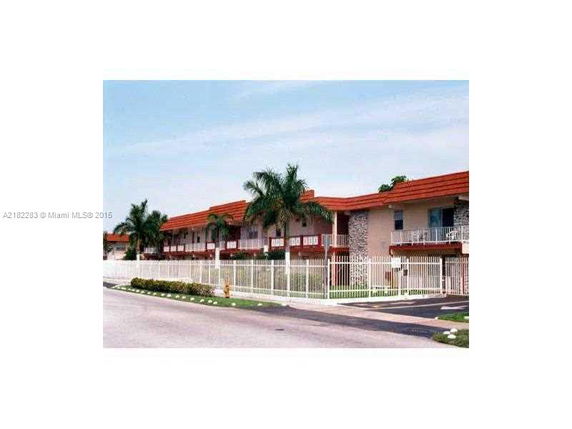 Front view of a two-story building with red roofs and balconies.