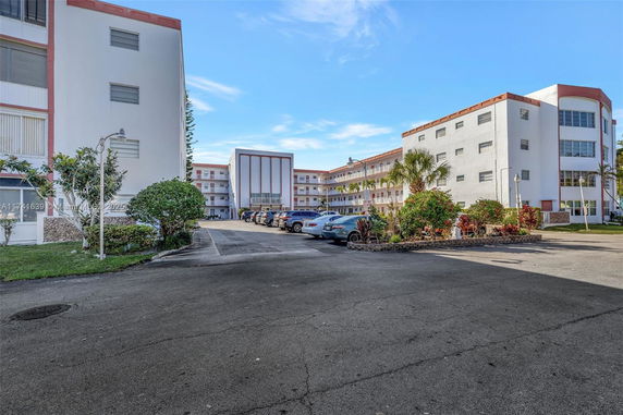 Outdoor parking area in front of multi-story residential buildings.