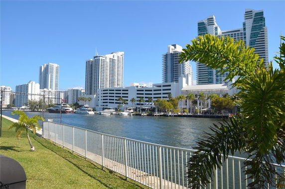 View of high-rise buildings and waterfront area with boats docked along the waterway.