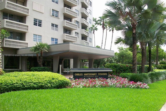 Front view of a multi-story building with a prominent entrance and balconies.