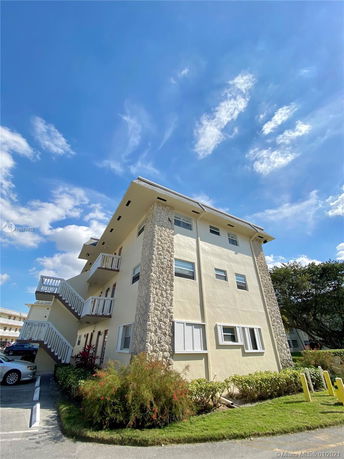 Front view of a multi-story building with balconies and stone accents.