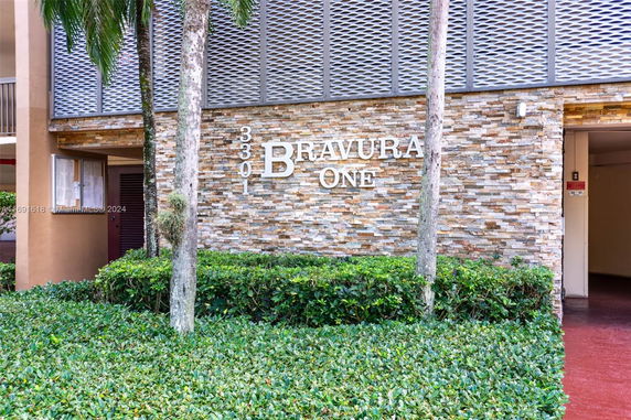Front view of a building with a stone facade and signage reading 3301 Bravura One.