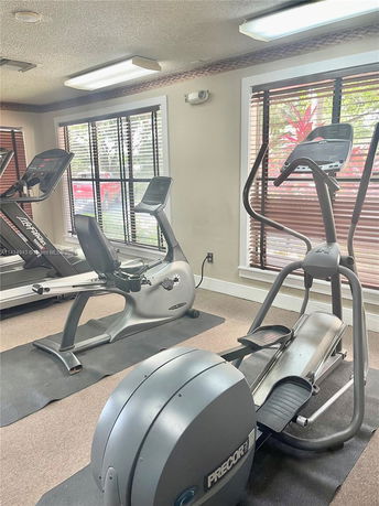 Indoor gym area with exercise equipment including a treadmill and elliptical machines.