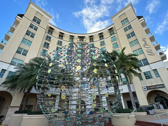 Front view of a multi-story building with a curved facade and large windows.