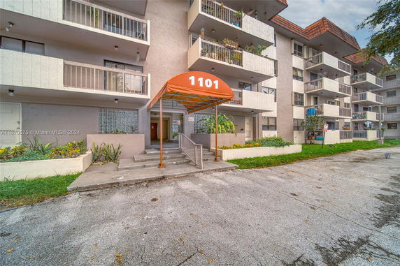 Front view of a multi-story residential building with balconies and an entrance canopy labeled 1101.