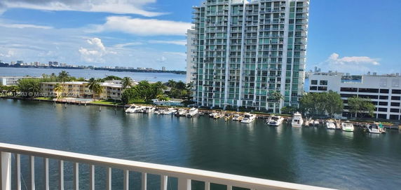 View of a waterfront with high-rise buildings and boats docked along the shore.