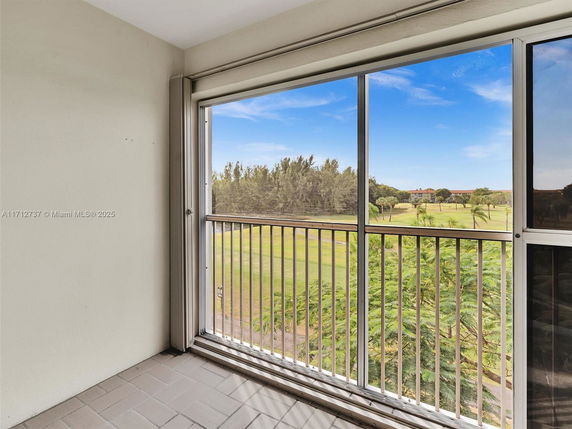Balcony view overlooking a green landscape and trees.