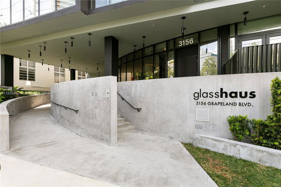 Front view of a building with a curved ramp and stairs leading to the entrance, marked 'glasshaus 3156 Grapeland Blvd.'